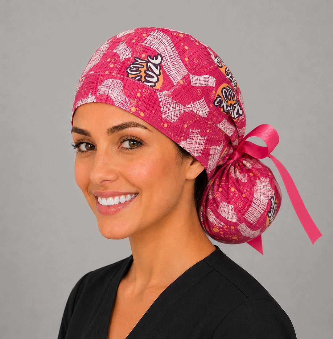Oh My Gauze ponytail nurse cap right three-quarter angle on smiling model showing pink gauze print, funny text and pink grosgrain ribbon bow