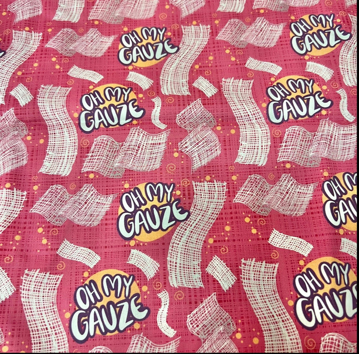 Fabric detail of the Oh My Gauze scrub cap — close-up of white gauze strips and lettering on raspberry pink cotton