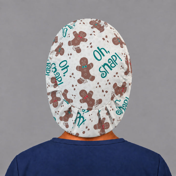 Back view of the Oh Snap gingerbread Euro scrub cap — elastic gathered back showing gingerbread men and crumbs across the cream crown