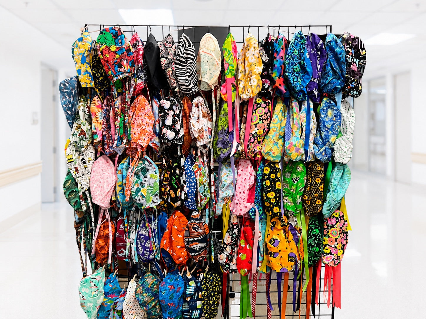 Beautiful OR World pop up display featuring hundreds of colorful handmade scrub caps for nurses, surgical techs, physicians, veterinarians, and healthcare professionals at a live shopping event.
