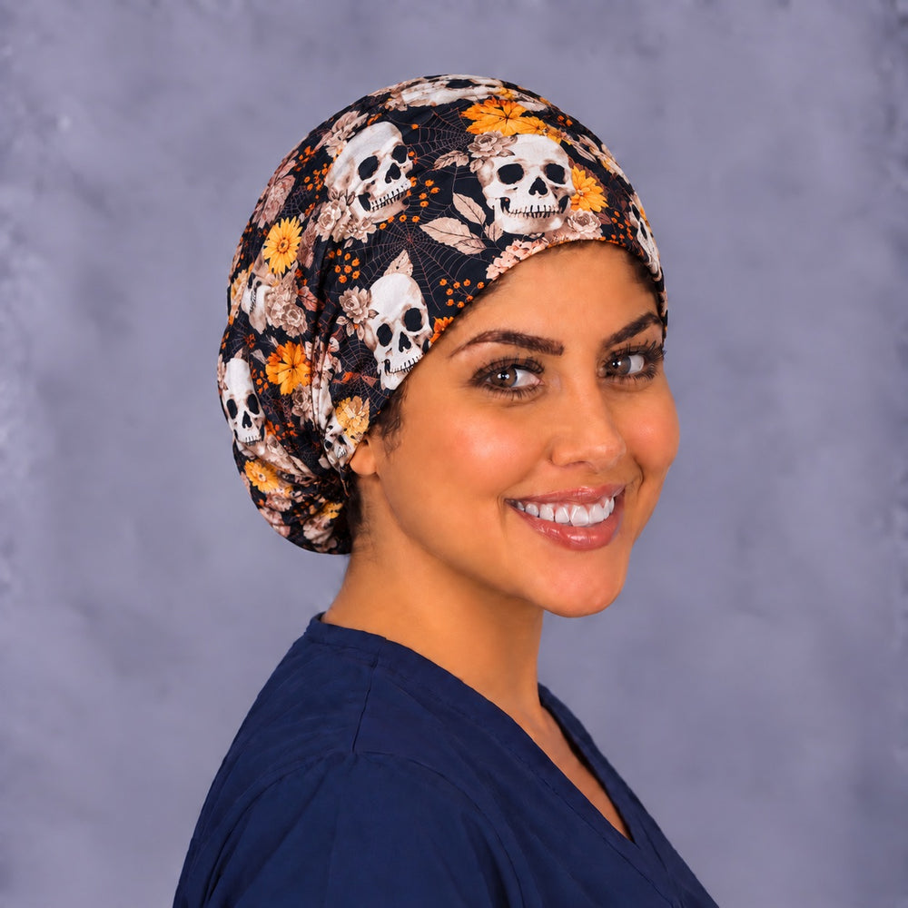 Three-quarter angle of an orange floral skull nurse cap, with fine spiderwebs and orange berries across the smooth front band