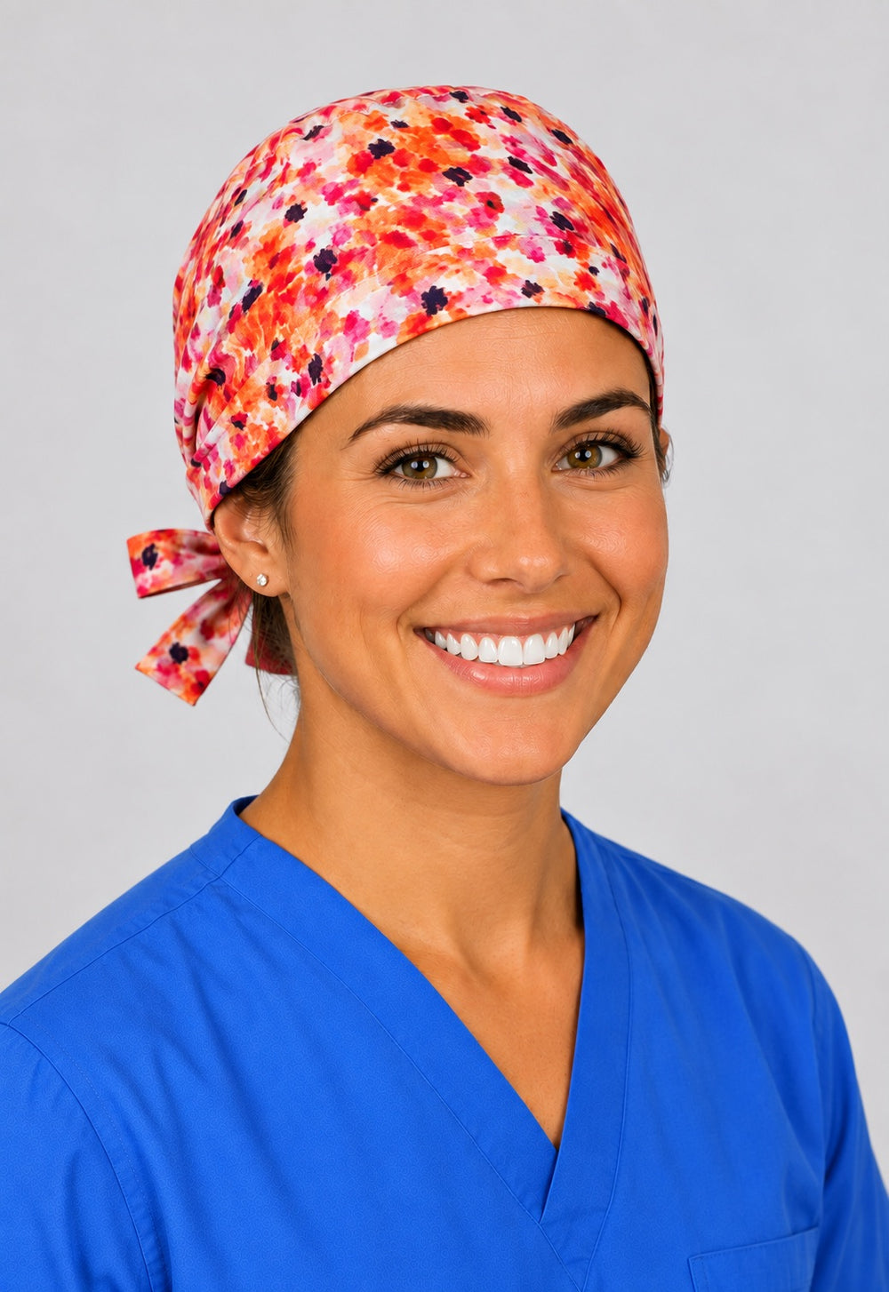 Nurse in orange sunset speckle tie back scrub cap, three quarter view of watercolor confetti surgical hat for short hair by OR World