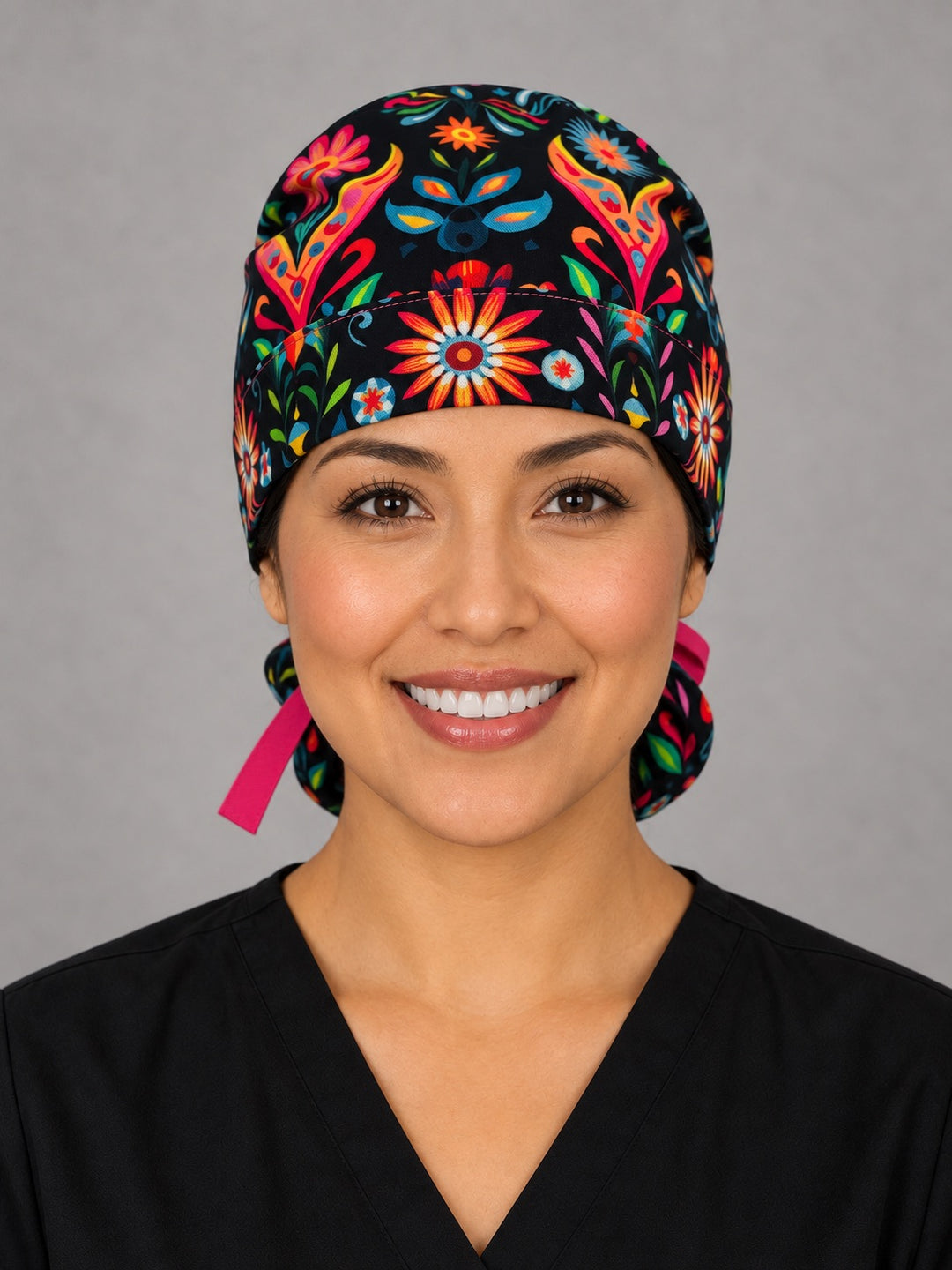 Otomí floral ponytail surgical hat, right angled view — hot pink grosgrain bow over the deep ponytail pouch, breathable cotton cap