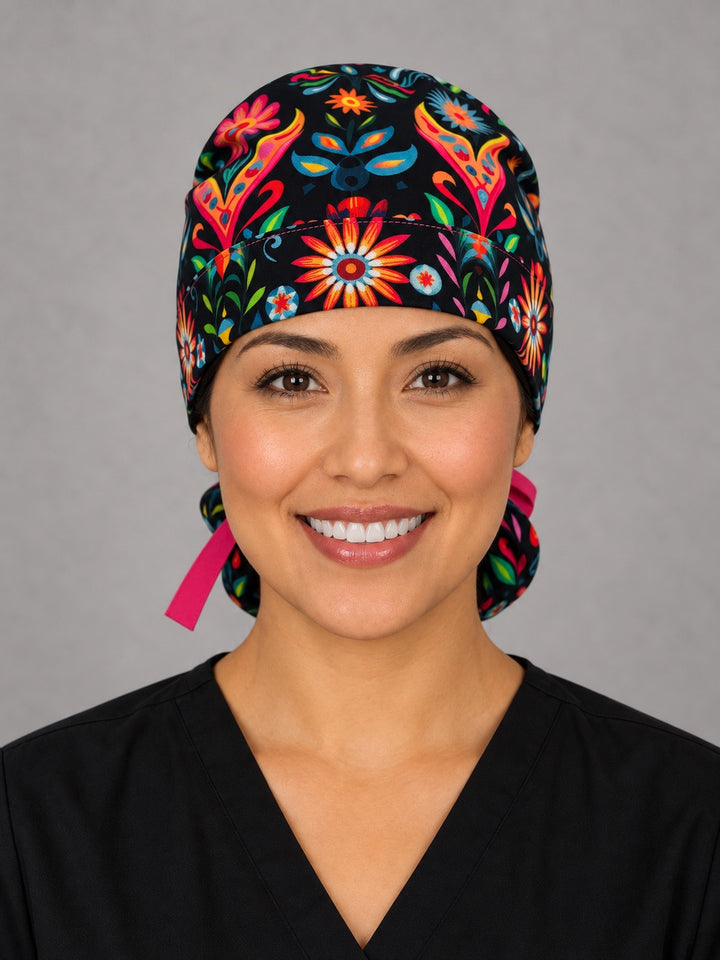 Otomí floral ponytail surgical hat, right angled view — hot pink grosgrain bow over the deep ponytail pouch, breathable cotton cap