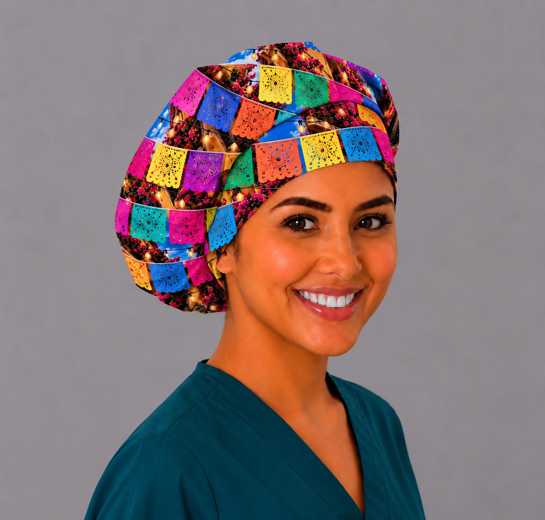 Smiling nurse in a papel picado bouffant scrub cap with colorful Mexican fiesta banners and glowing string lights