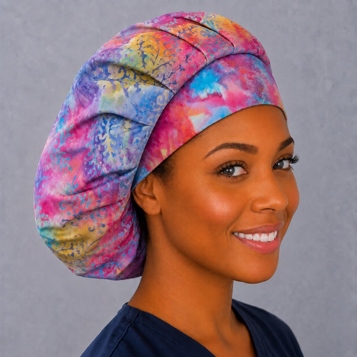 Back view of the pastel batik bouffant scrub cap — full gathered fit showing hand-dyed paisley and fern detail across the crown
