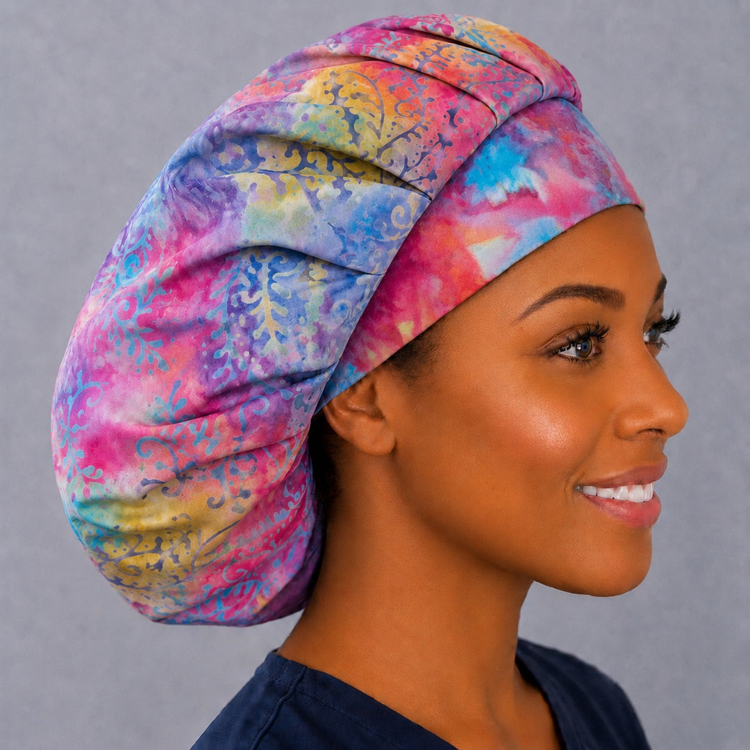 Pastel candyland bouffant scrub cap, left angled smiling view — roomy elastic-back cap that secures long thick or braided hair