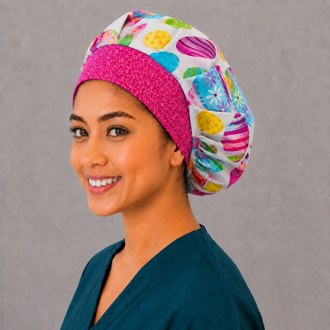 Pastel Easter bouffant scrub cap, left angled smiling view — painted eggs with stripes, dots and daisies for OR nurses and surgical techs