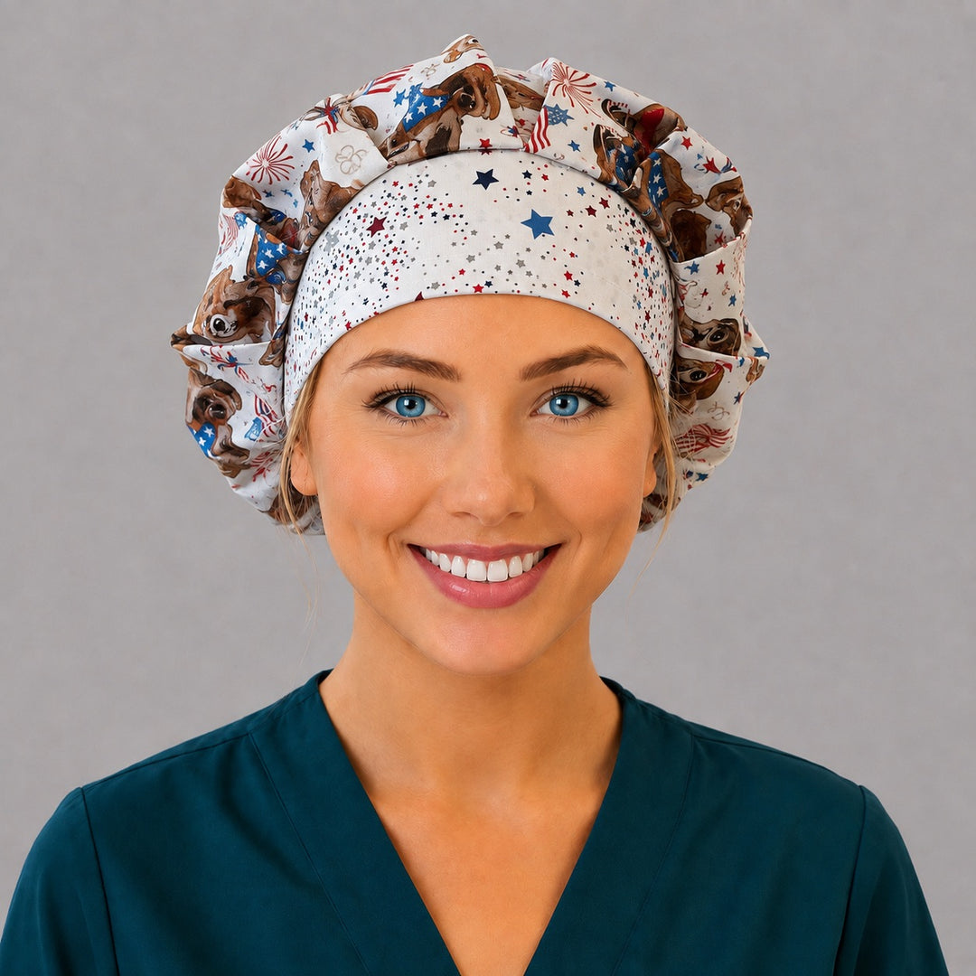 Woman wearing a patriotic dog bouffant scrub cap, front view — flag-bandana puppies and fireworks on cream with a star-print band, adjustable women&