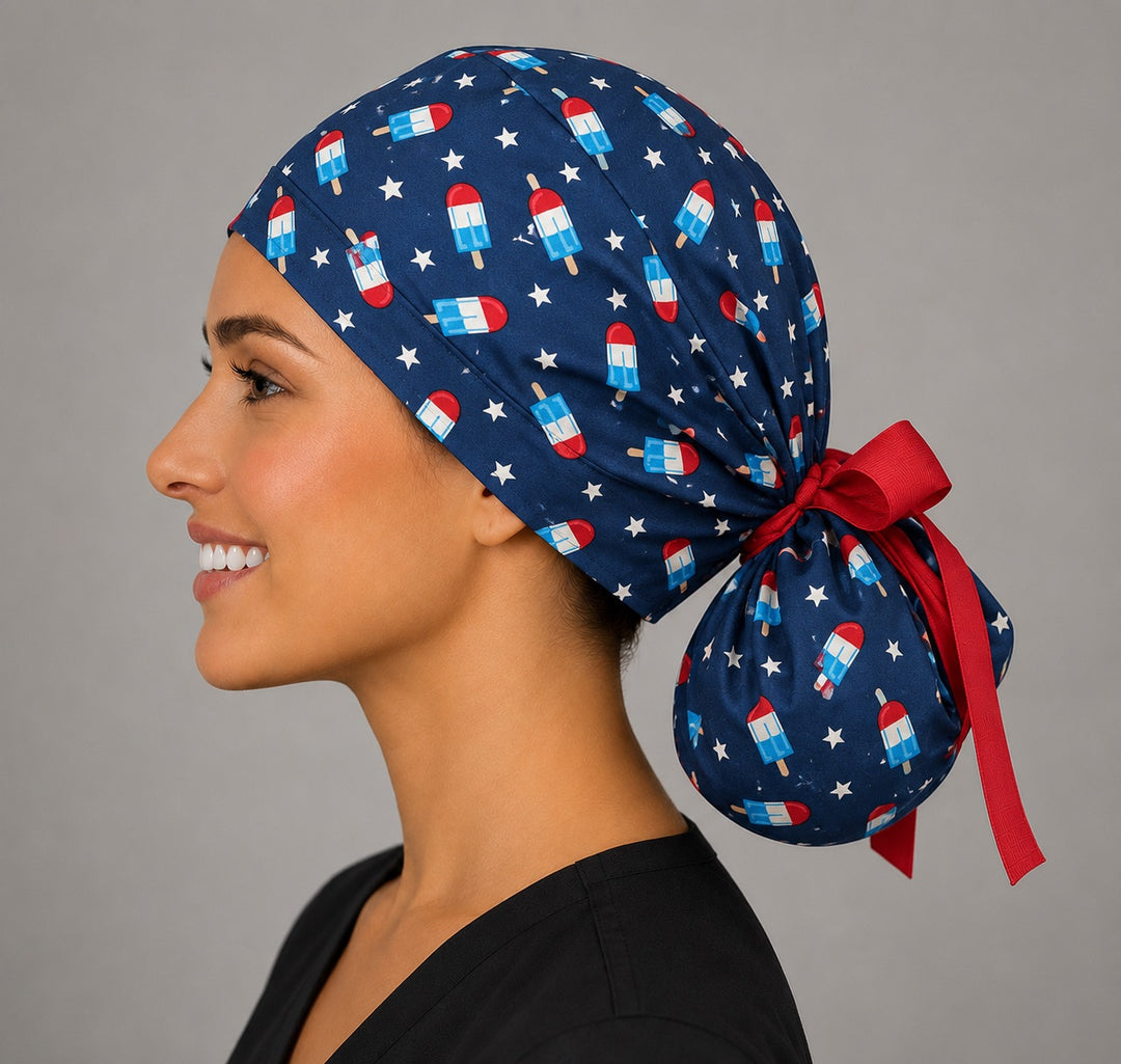 Patriotic popsicle ponytail scrub cap right side profile showing gathered pouch of popsicles and stars on navy with red ribbon tie