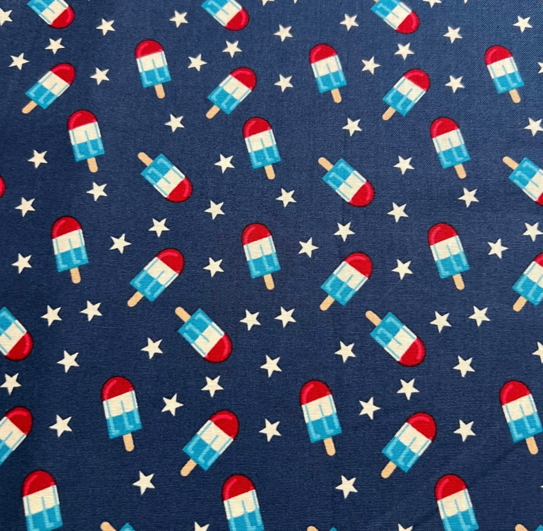 Fabric detail of the Patriotic Popsicle scrub cap — close-up of striped popsicles and stars on navy cotton