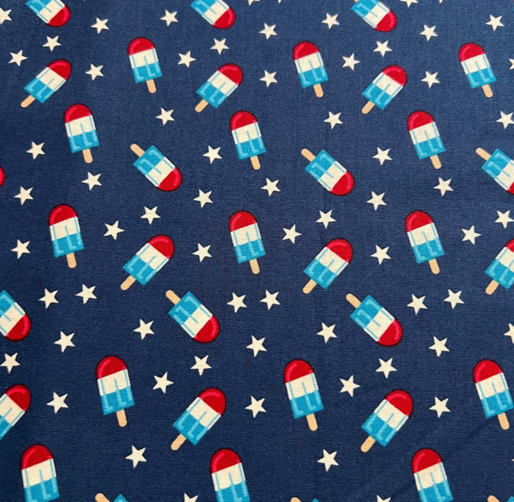 Fabric detail of the Patriotic Popsicle scrub cap — close-up of striped popsicles and stars on navy cotton