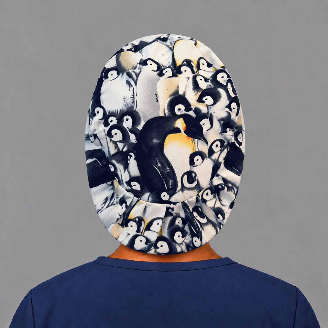 Back view of the penguin Euro scrub cap — elastic gathered back showing the full penguin colony print