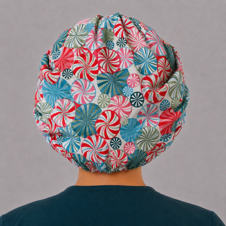 Back view of the peppermint bouffant scrub cap — full gathered fit showing candy swirls in red, teal, pink and green across the crown