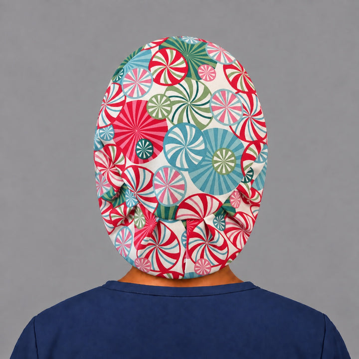 Back view of the peppermint swirl Euro scrub cap — elastic gathered back showing candy swirls across the cream crown