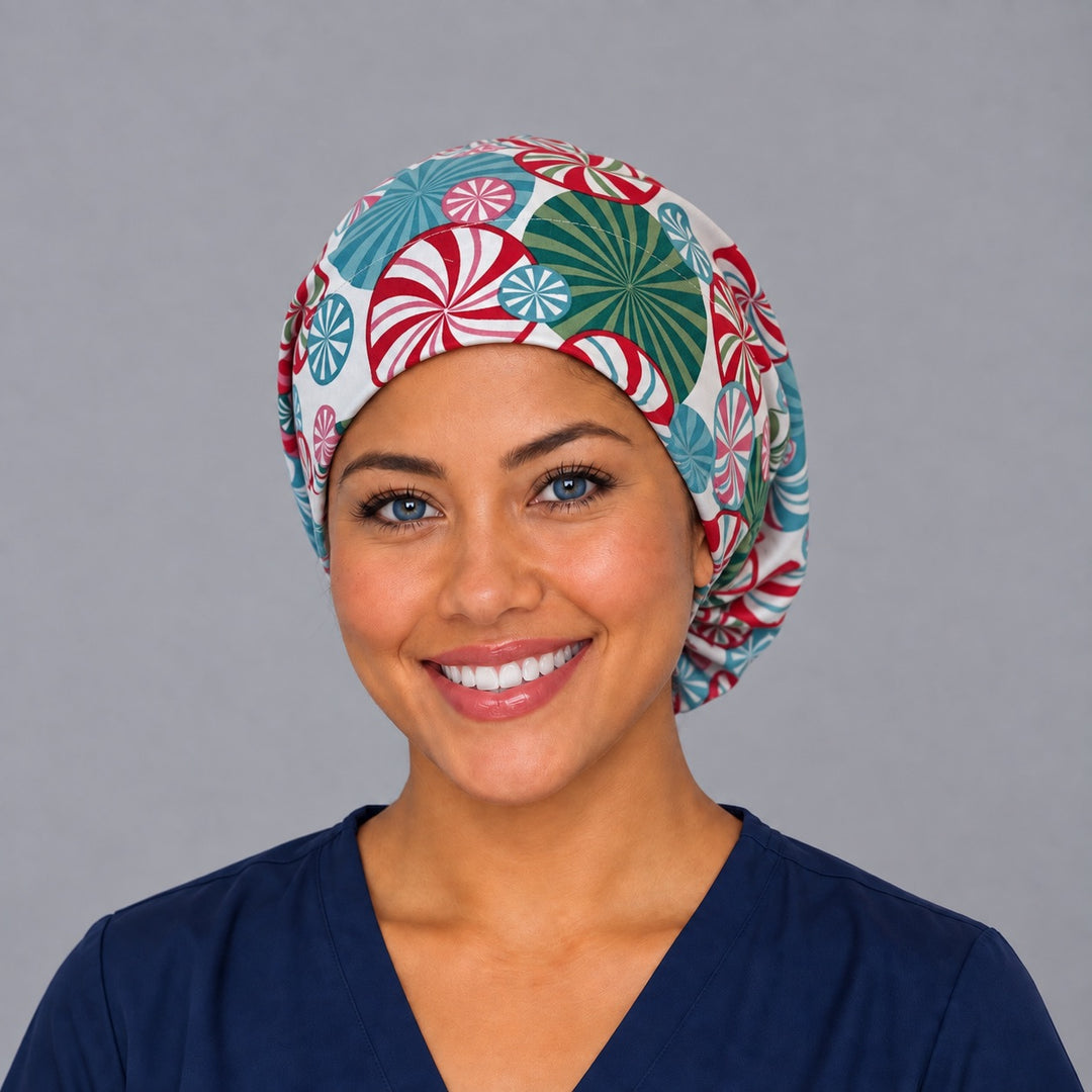 Woman wearing a peppermint swirl Euro scrub cap, front view — red, teal and pink peppermint candies on cream, adjustable holiday surgical hat