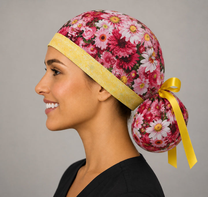 Pink daisy floral ponytail scrub cap back view showing gathered pouch full of pink daisies and yellow ribbon bow