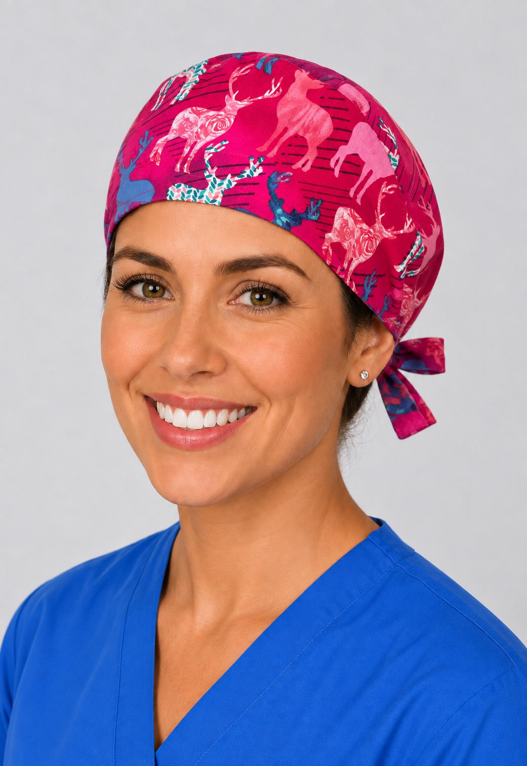 Nurse wearing pink deer print tie back scrub cap, magenta floral stag surgical hat with side tie by OR World