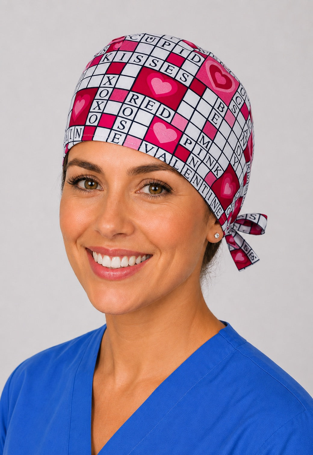 Three-quarter view of pink heart crossword puzzle unisex Valentine's surgical hat for nurses and surgical techs