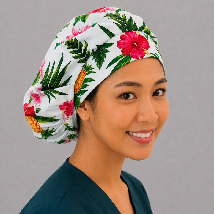 Pink hibiscus bouffant scrub cap, left angled smiling view — island floral print for OR nurses and surgical techs