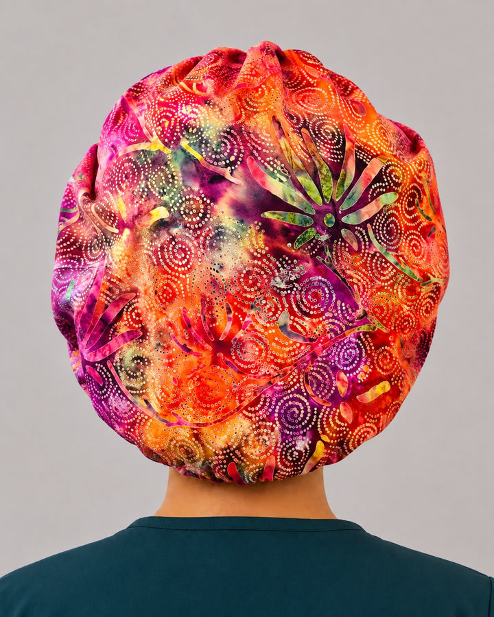 Back view of the pink and orange batik bouffant scrub cap — full gathered coverage showing swirled starburst batik print