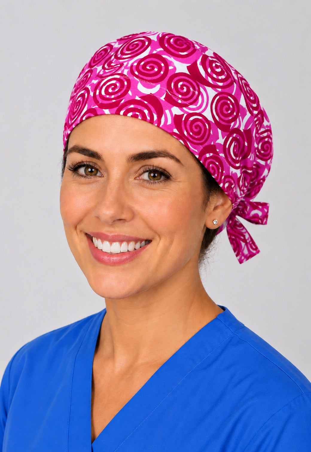Nurse wearing pink rose swirl tie back scrub cap, magenta Valentine surgical hat with side tie by OR World