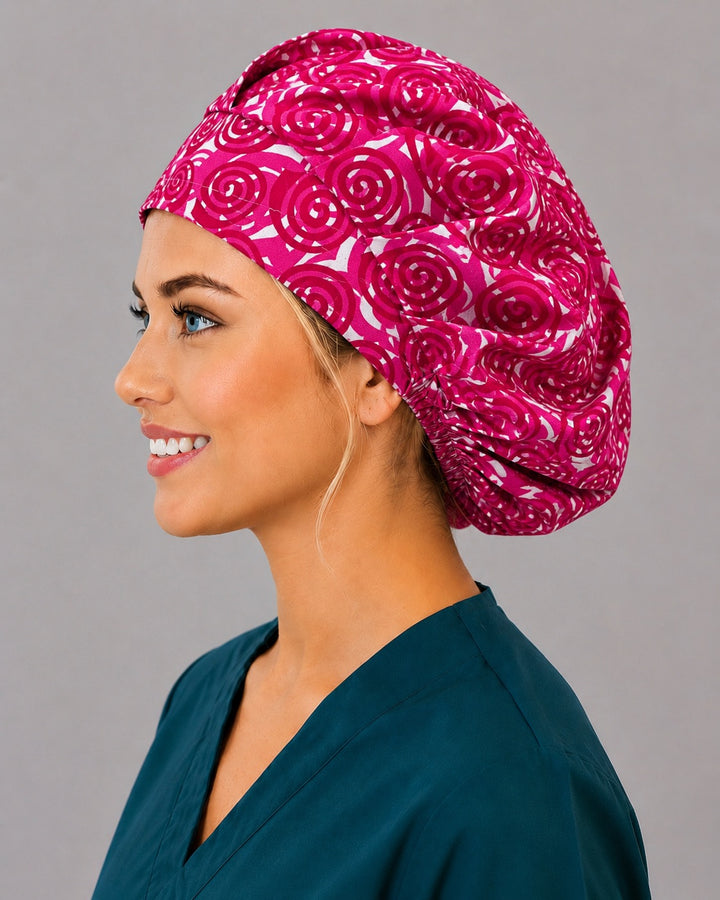Pink spiral bouffant scrub cap, left side profile — abstract rosette print for OR nurses and surgical techs