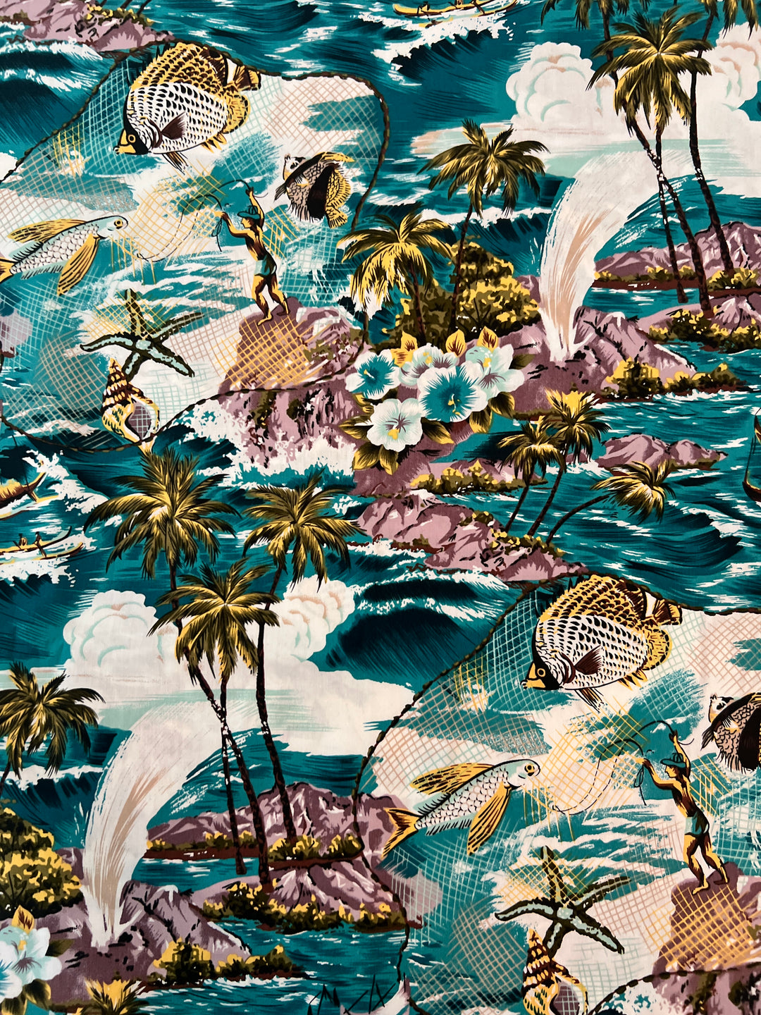 Close-up of the Polynesian fishing scrub cap fabric showing the vintage tropical print — teal ocean, palms, leaping fish, starfish, shells and island fishermen