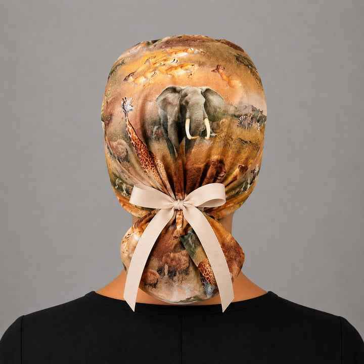 Back view of African safari ponytail surgical cap for women with elephant, giraffe, zebra print and adjustable bow tie
