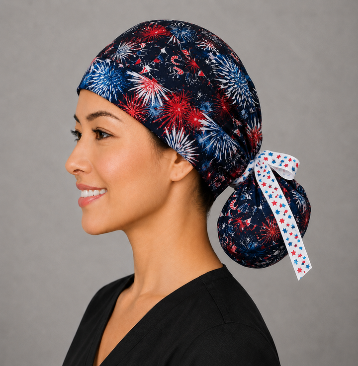 Side view of patriotic fireworks ponytail scrub cap holding long hair in navy with USA print and white star ribbon tie