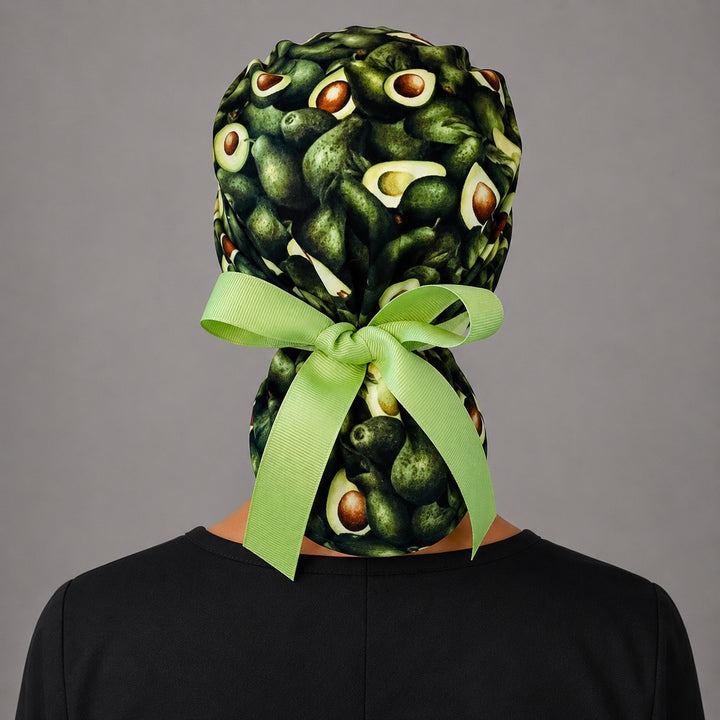 Avocado print ponytail scrub cap back view on mannequin showing double gathered pouch and lime green ribbon bow