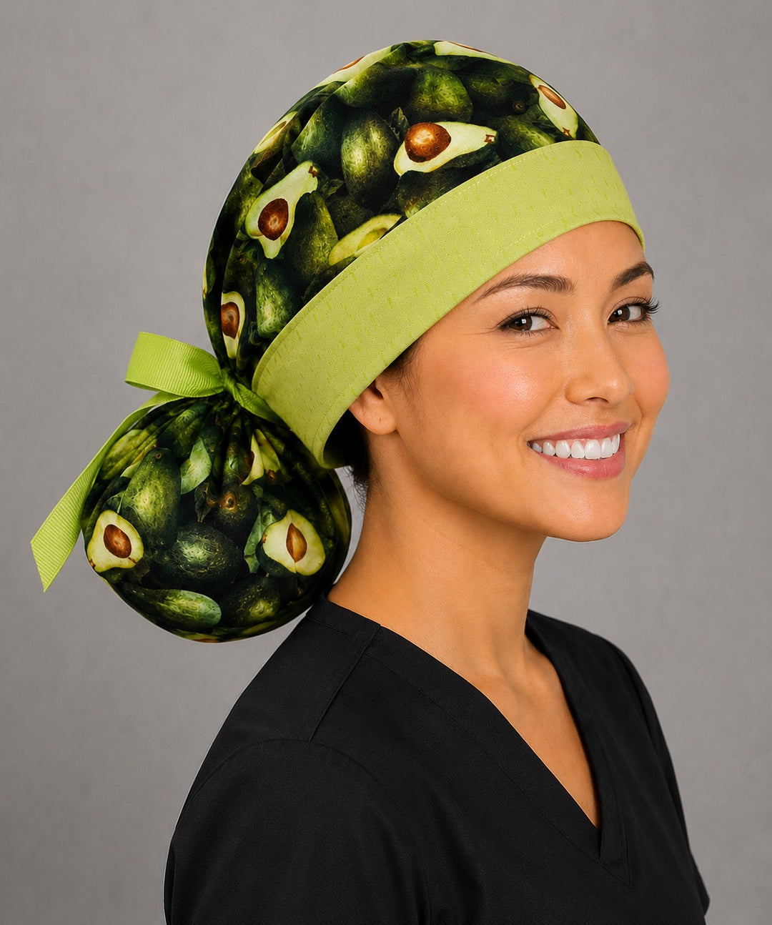 Avocado print ponytail nurse cap left three-quarter angle showing full ponytail pouch of avocados and green band