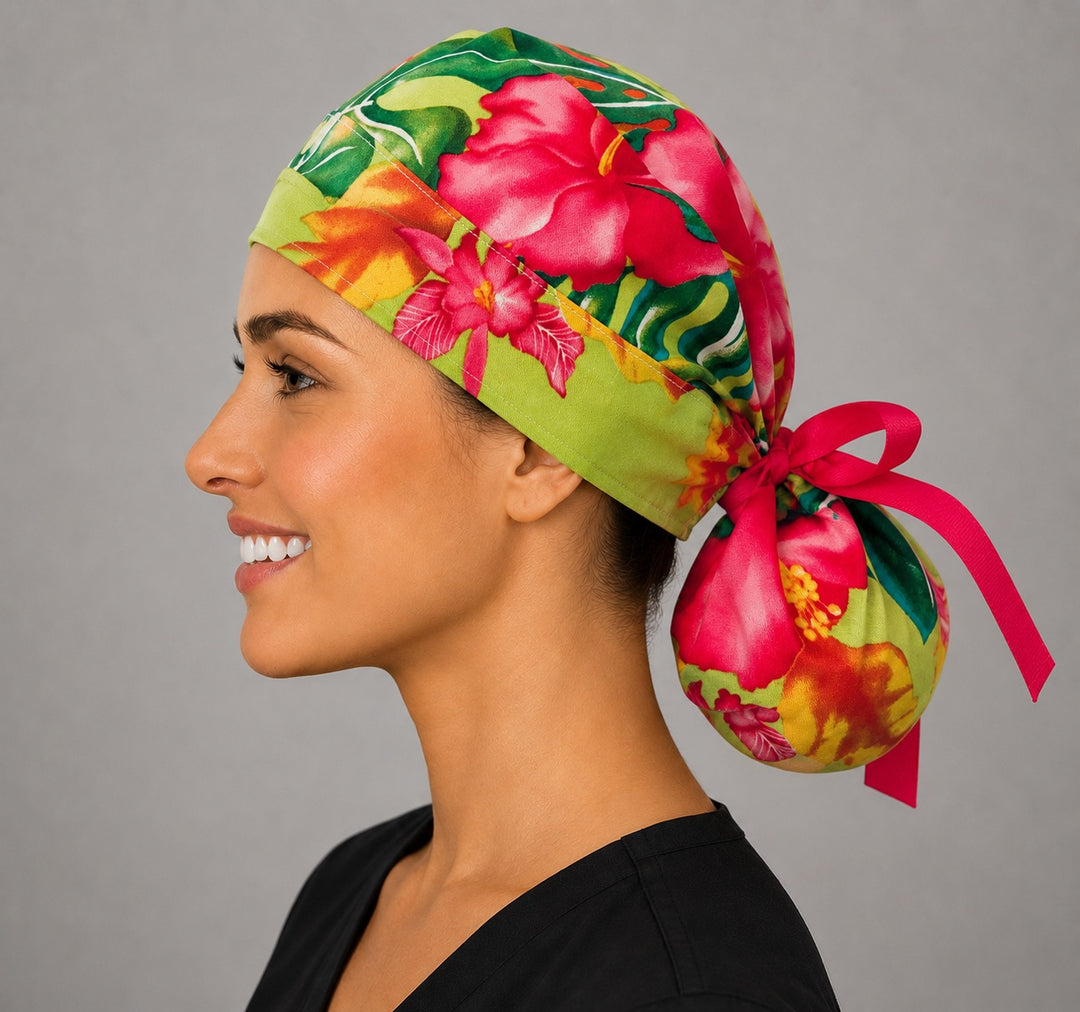 Hawaiian hibiscus tropical ponytail scrub cap left profile view showing full ponytail pouch of tropical flowers and long hot pink ribbon ties