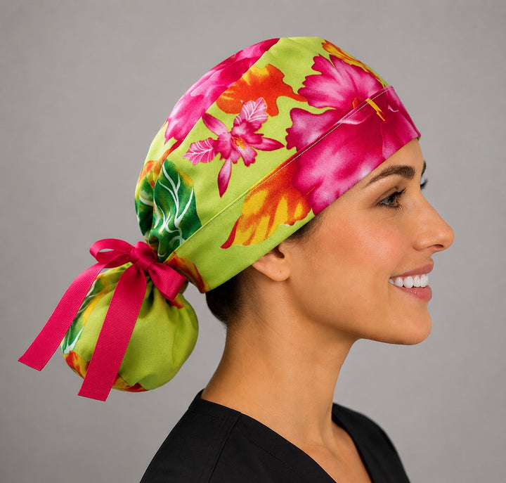 Hawaiian hibiscus tropical ponytail surgical cap left side profile with lime green base, pink hibiscus print and hot pink grosgrain ribbon tie