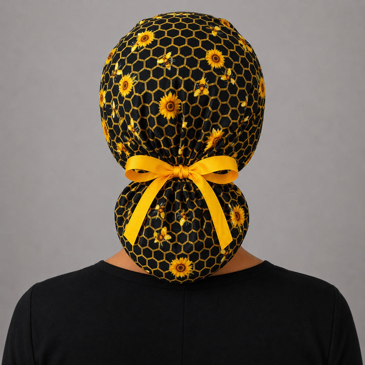 Honey bee honeycomb ponytail scrub cap back view on mannequin with double gathered pouch and gold ribbon bow