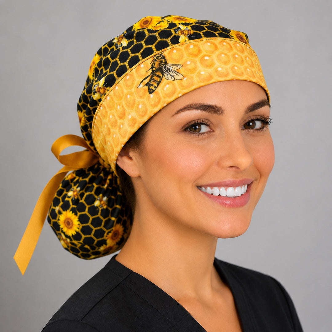 Woman wearing honey bee and honeycomb ponytail scrub cap, right front angle showing honeycomb band with detailed bee