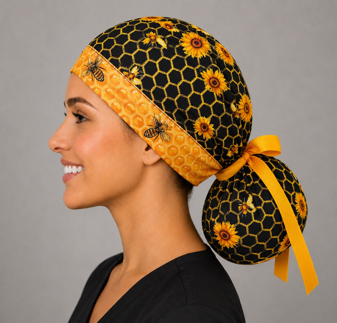 Honey bee honeycomb ponytail scrub cap side view showing gathered pouch for long hair and gold grosgrain bow