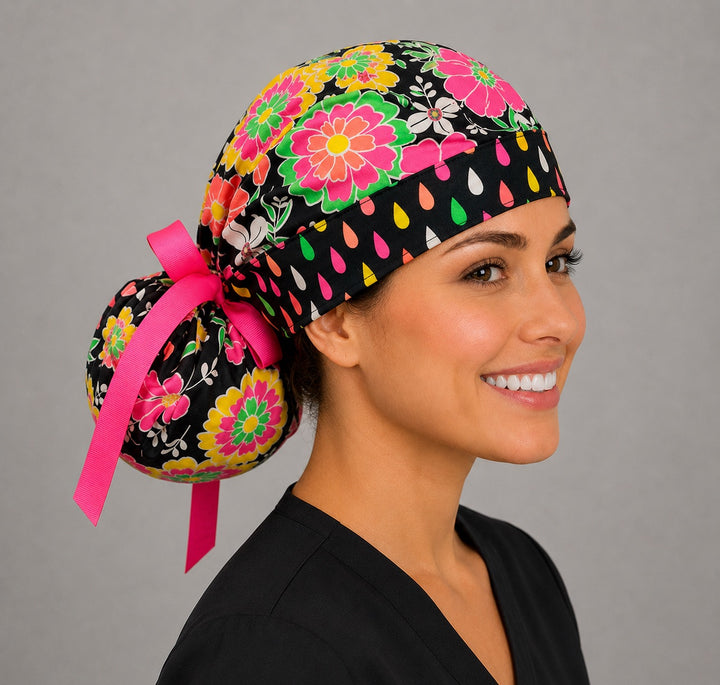 Angled side view of neon floral bouffant ponytail scrub cap showing gathered pouch and pink tie-back bow