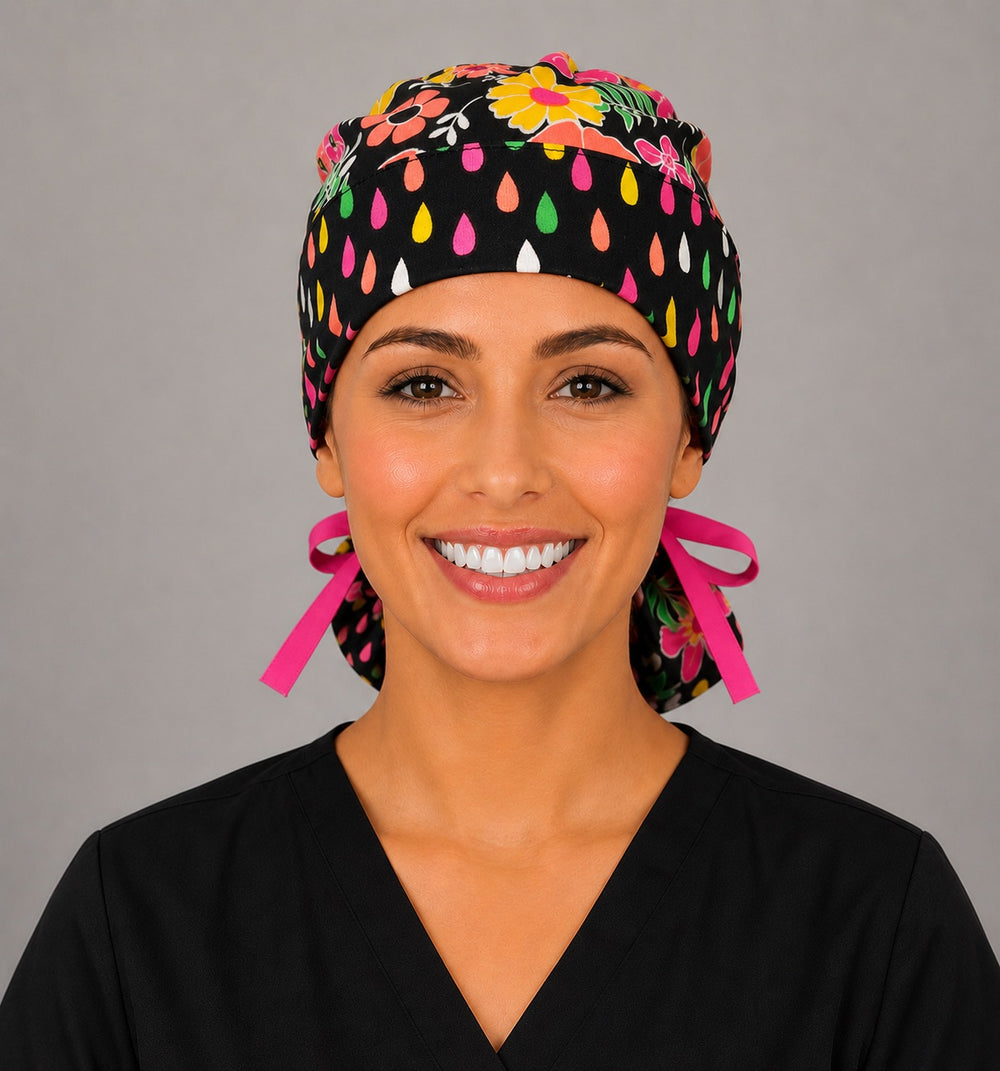 Front view of neon floral ponytail scrub cap for women with teardrop trim band and pink ribbon ties