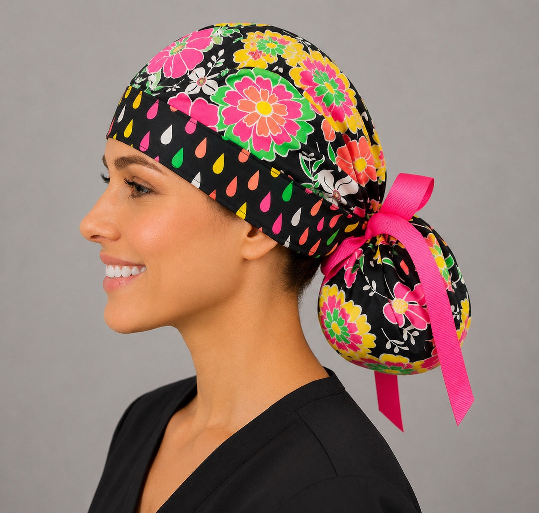 Left profile of woman in black neon floral ponytail surgical cap with adjustable pink ribbon tie-back