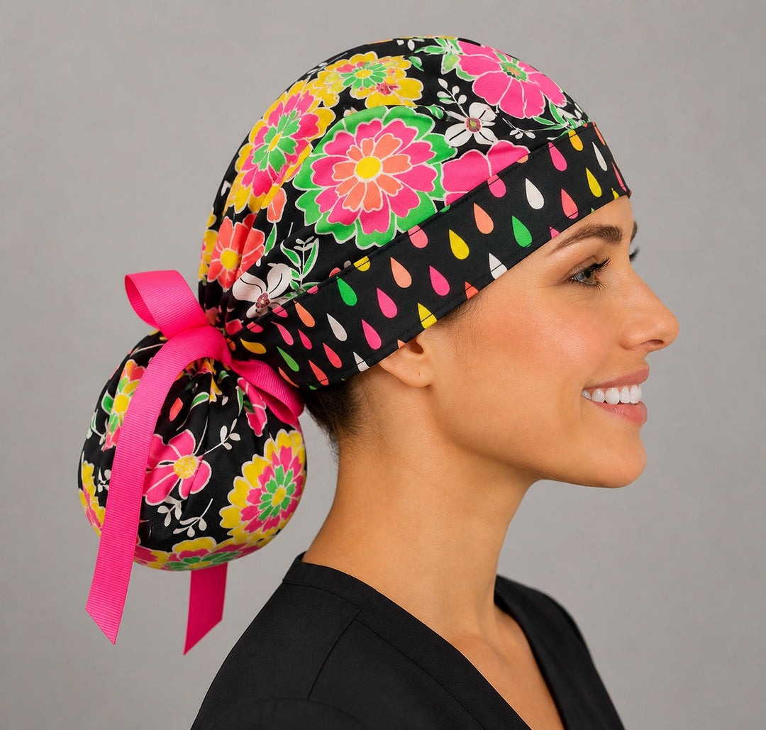 Side view of woman wearing neon floral ponytail scrub cap with pink ribbon bow and full ponytail pouch