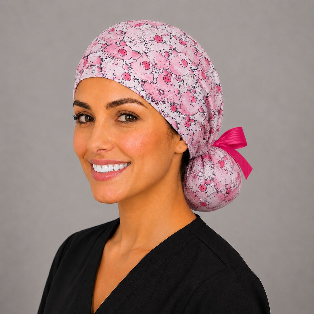 Pink pig ponytail nurse cap right three-quarter angle on smiling model showing cartoon pigs print and hot pink grosgrain ribbon bow