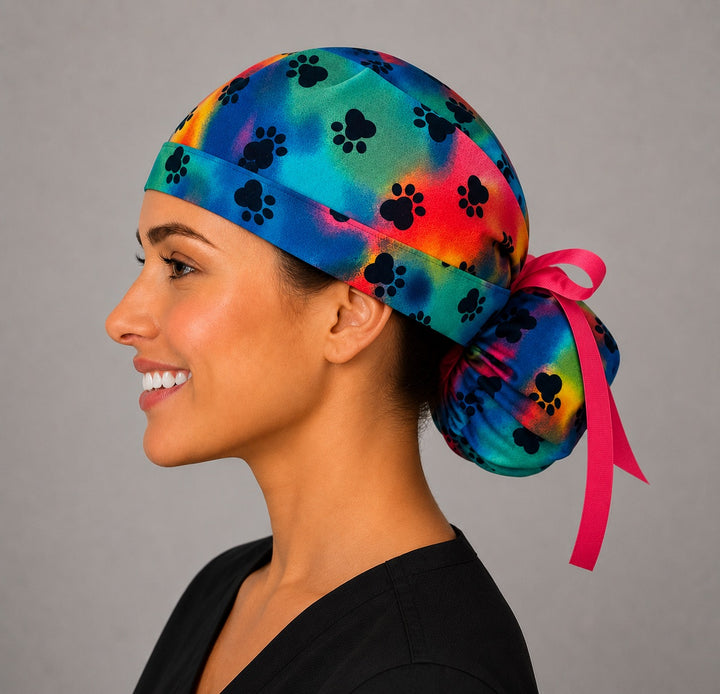 Tie dye puppy paw rainbow ponytail scrub cap right side profile with rainbow paw print band and hot pink ribbon tie-back