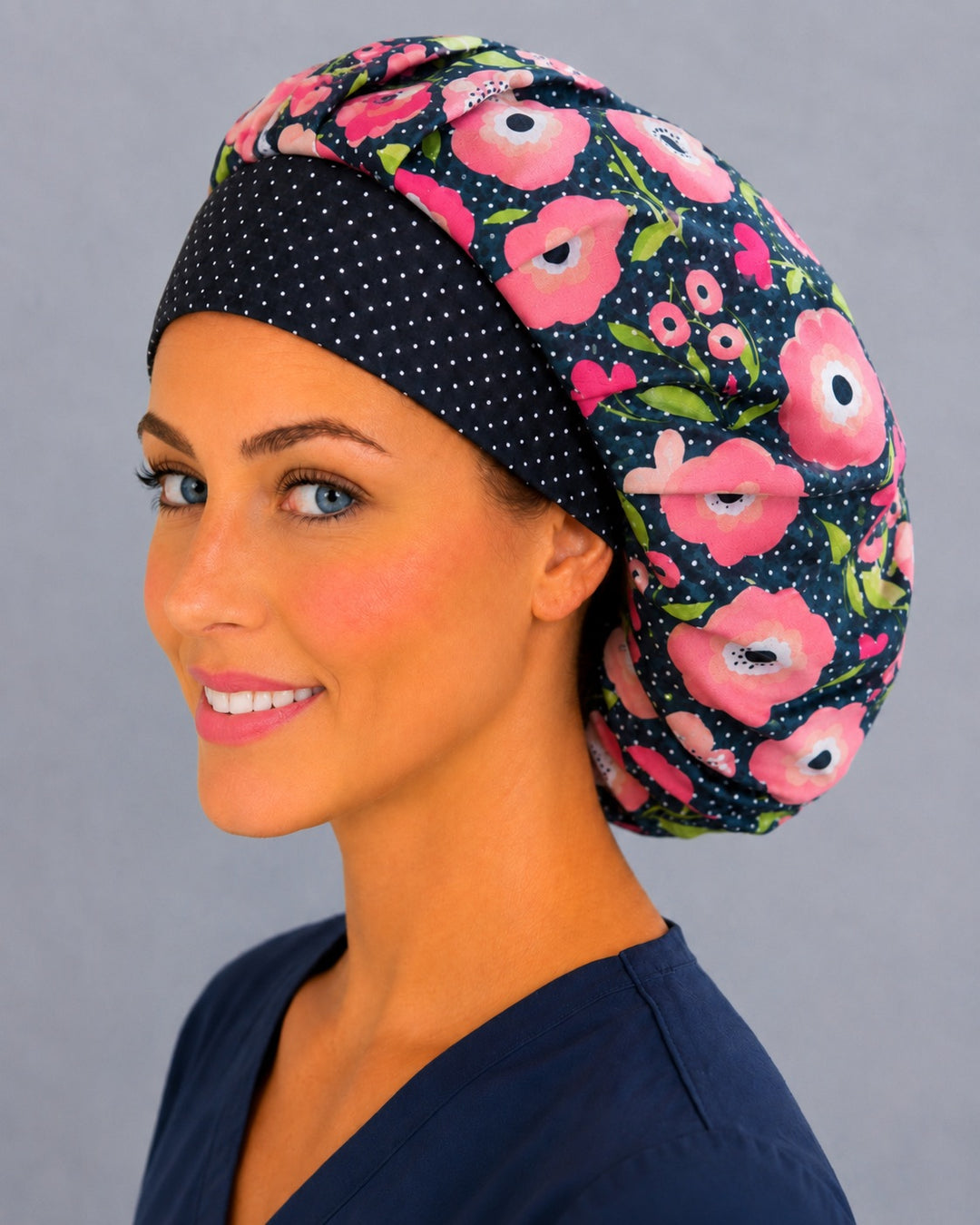 Poppy flower bouffant surgical cap for women, three-quarter view — pink and peach blooms on polka dot black, breathable cotton