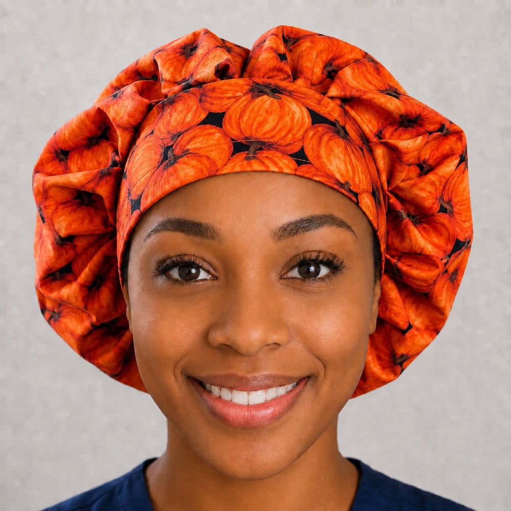 Woman wearing a pumpkin patch bouffant scrub cap, front view — orange pumpkins on navy, adjustable women's surgical hat for long hair