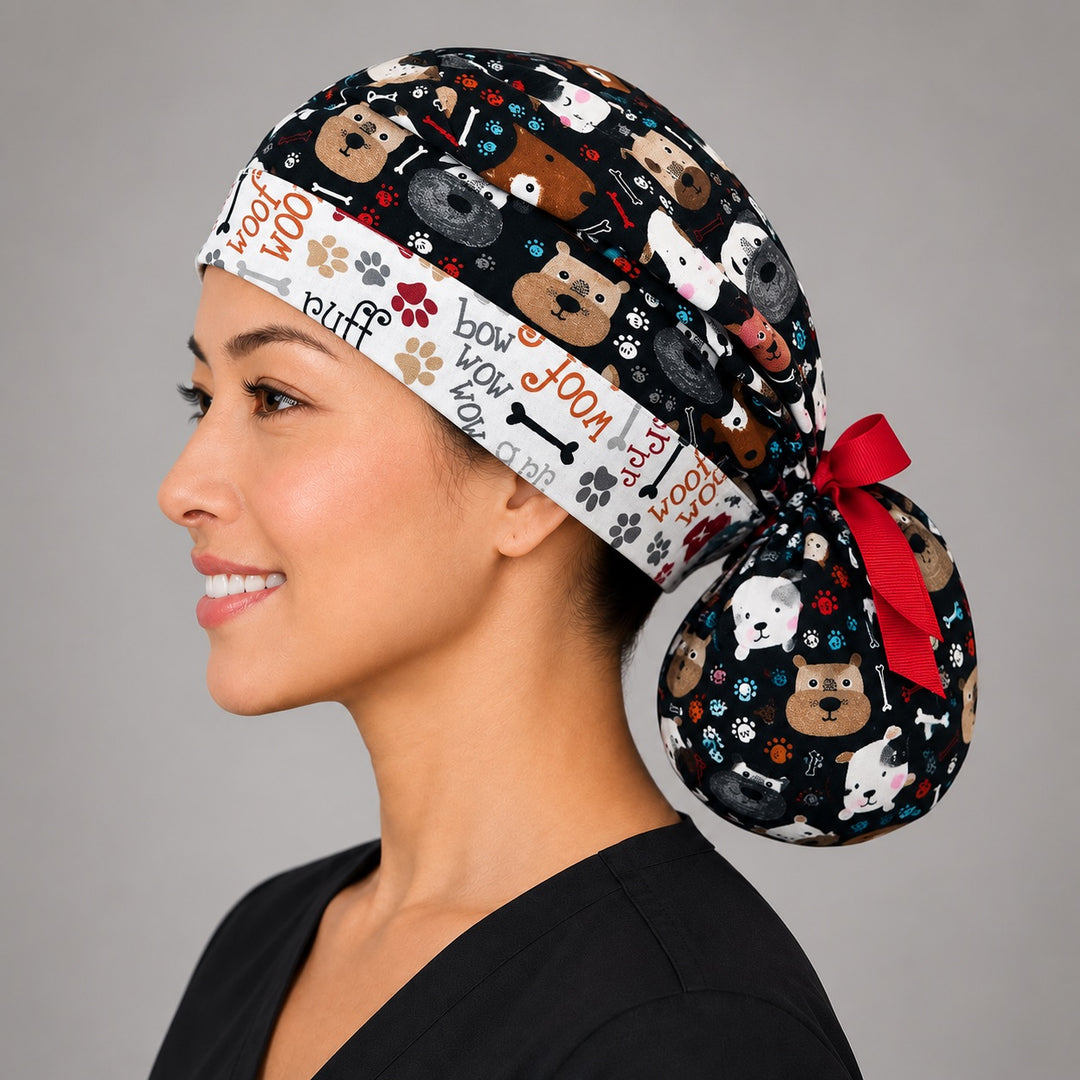 Puppy dog lover ponytail scrub cap left side profile with full ponytail pouch of cartoon dog faces on black and long red ribbon ties