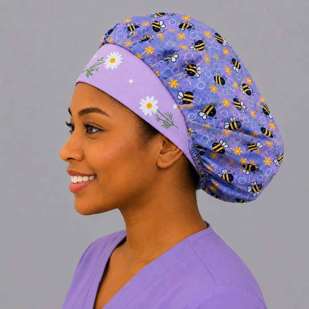 Angled view of the purple bumblebee bouffant scrub cap for women on a smiling nurse — handmade lavender floral surgical cap, USA made