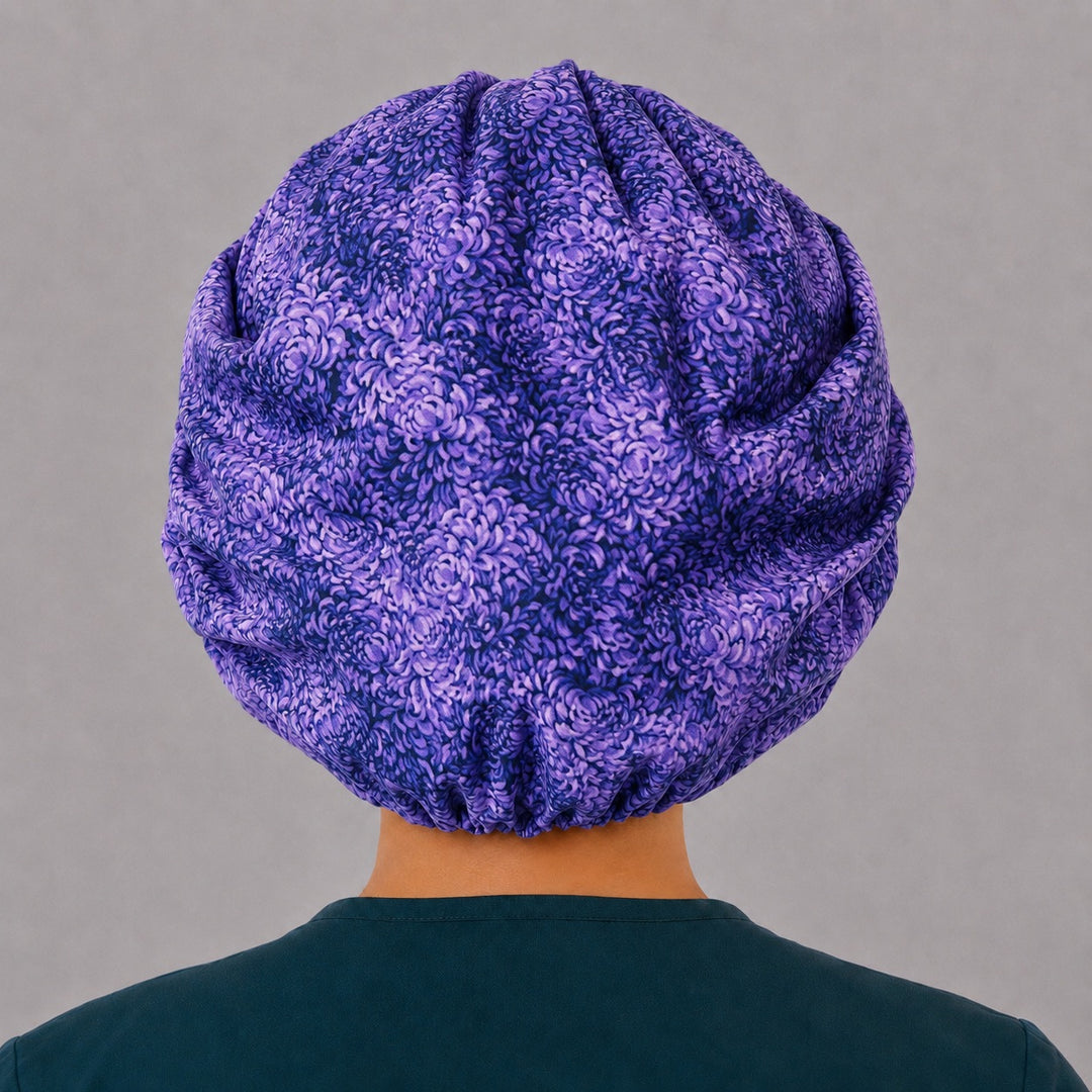 Back view of the purple floral bouffant scrub cap — full gathered coverage showing layered violet petals across the crown