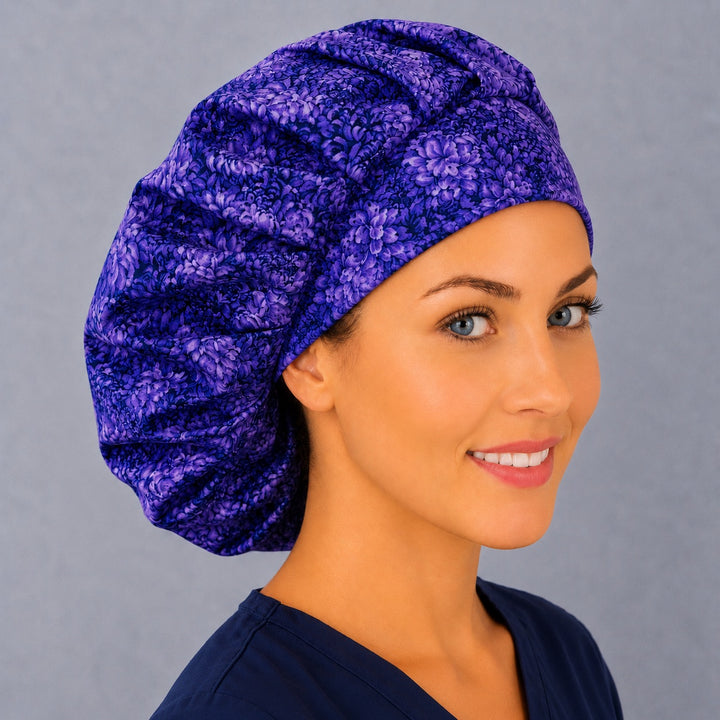 Purple petal bouffant cap for women, right angled smiling view — handmade violet floral surgical cap, USA made