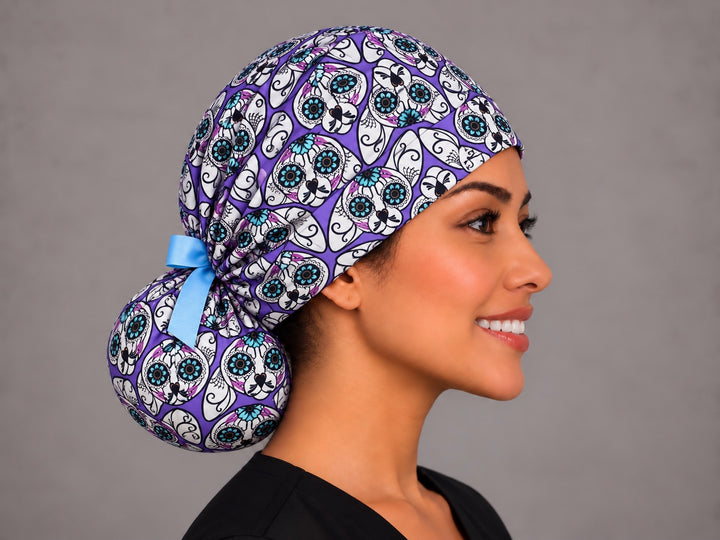 Right side profile of the purple sugar skull cat ponytail scrub cap — gathered pony pouch tied with a light blue ribbon